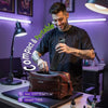 Tattoo artist placing the Phomemo M08F Plus portable tattoo stencil printer into a leather bag inside a tattoo studio, demonstrating compact size and portability